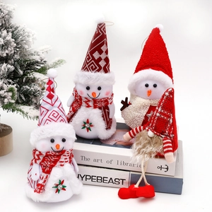 Christmas snowman and long-legged dolls decor on books with mini Xmas trees