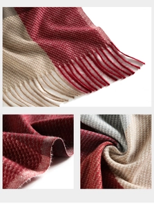 Detail view of plaid knit scarf featuring fringe tassels and thick cashmere-like texture