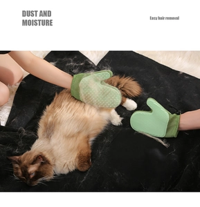 Close-up of green silicone pet grooming glove removing loose fur from a white rug