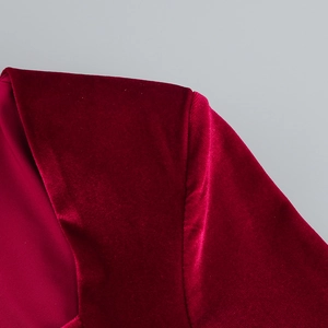 Gros plan d'une robe en velours rouge avec décolleté en V et texture plissée riche