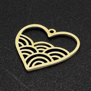 Detailed view of a golden heart-shaped pendant with wave patterns and a small hanging hole