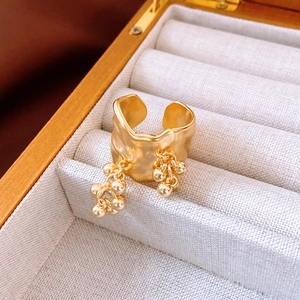 Macro view of 18K gold plated irregular lava texture ring with fringe bead tassels