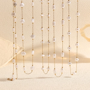 Macro view of Baroque pearls and 18k gold plated stainless steel shell necklaces