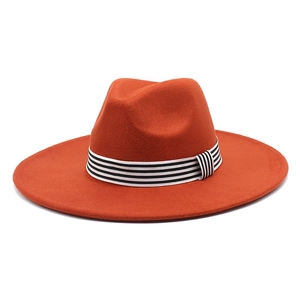 Orange wide brim wool fedora hat with black and white striped band for stylish autumn fashion
