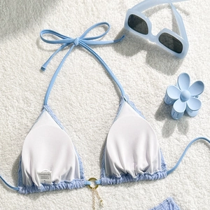 Detail of light blue textured bikini top with golden ring and pearl pendant decoration