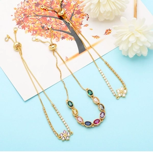 Macro detail of three gold-plated zircon flower bracelets with colorful gemstones and slider