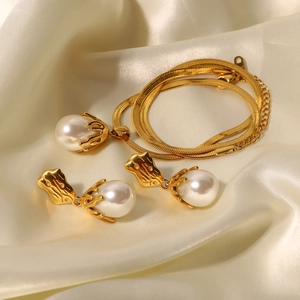 Baroque pearl pendant necklace and earrings set on silk fabric, elegant gold jewelry