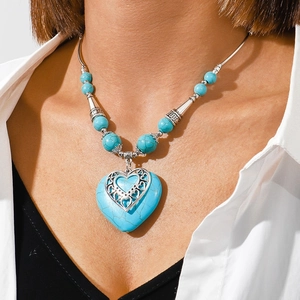 Close-up of Bohemian heart turquoise pendant necklace on a model's neck for styling
