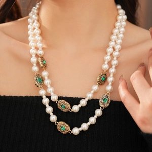 Dettaglio della collana di perle vintage a doppio strato con pietre preziose verdi