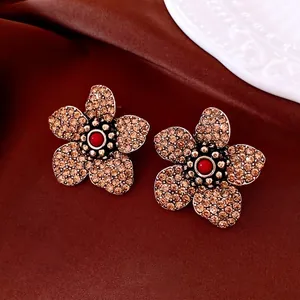 Vintage flower earrings with amber crystals and red beads on brown silk background