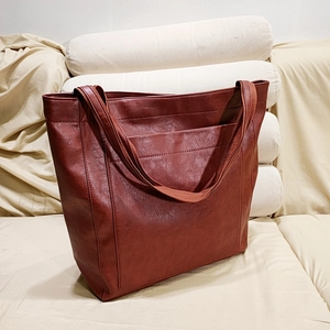 Détail d'un sac cabas marron en similicuir vintage avec poche frontale extérieure