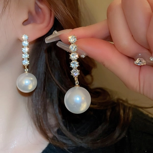 Boucles d'oreilles pendantes dorées avec zircons verticaux et grandes perles blanches