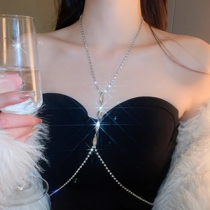 Detail view of a sparkling silver rhinestone body chain draped over a black dress
