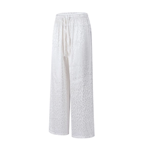 Detail of white leopard print wide-leg trousers with elastic drawstring waist and silky texture