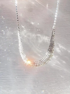 Macro detail of silver multi-row rhinestone fringe necklace with luxurious tassel design