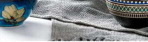 Close-up of Japanese ceramic rice bowls with floral and geometric patterns on a grey woven mat