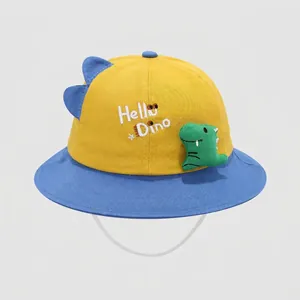 Detail of yellow and blue kids sun hat with 3D dinosaur plush and Hello Dino embroidery