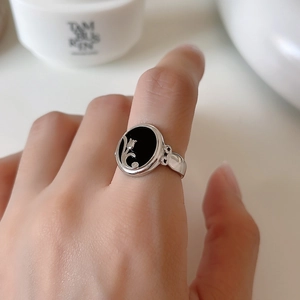 Detailed view of vintage silver ring featuring black onyx with tulip floral relief