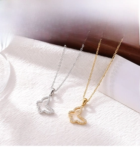 Close-up of gold and silver butterfly pendant necklaces with sparkling micro zircons