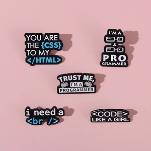 Close-up of five black enamel programmer pins featuring CSS and HTML code on pink background