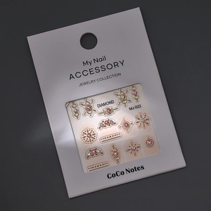 Macro shot of gold-embossed nail stickers with pink rhinestones in MJ-022 packaging