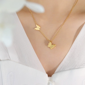 Elegant gold titanium steel necklace with matte and polished butterfly pendants worn on neck