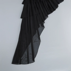 Detail view of multi-layered black mesh fabric with soft ruffled wave hem design