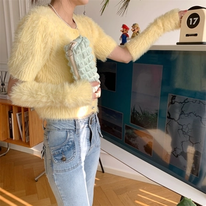 Detail of soft yellow faux mink knit top with matching detachable sleeves on model
