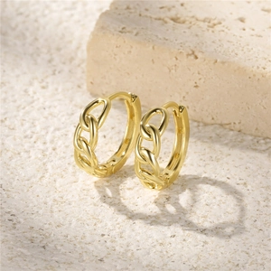 Macro shot of gold S925 sterling silver chain link earrings on a textured stone base