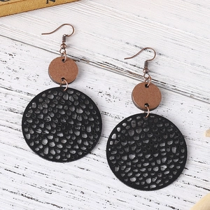 Detail of vintage geometric earrings with black cut-out discs and brown wooden accents
