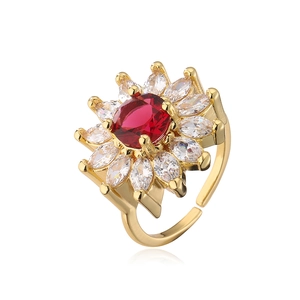 Detail of red gemstone flower ring with white zircon petals in gold-plated brass