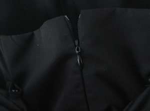 Detailed macro view of the black dress fabric texture and durable metal back zipper