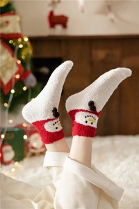 Close-up of fluffy Christmas socks with 3D snowman pattern and soft coral fleece texture