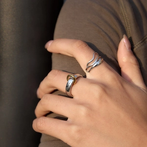 Modern minimalist 18K gold stainless steel rings with wavy design on a model