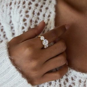 Close-up of 18K gold stainless steel ring with three large round white zircons on hand
