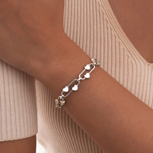Close-up of heart charms on a trendy stainless steel paperclip chain bracelet