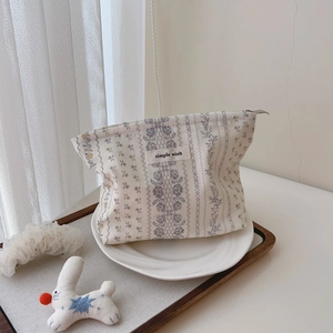 Detail of floral cotton makeup bag with metal zipper and simple wish label