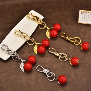 Polished cherry keychain with leaf charm in gold, silver and bronze metal finishes