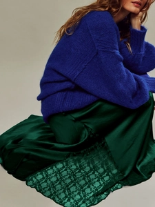 Detail showing dark green satin skirt with delicate lace hem and mohair knit texture