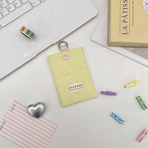 Detailed view of yellow quilted heart card holder with pink snap button and metal hook