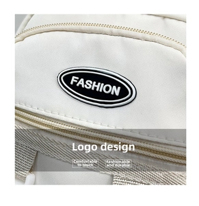 Dettaglio ravvicinato della borsa in tela crema con logo Fashion e zip in metallo