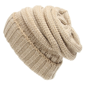 Close-up of beige knit beanie showing chunky texture and ribbed cuff for winter warmth