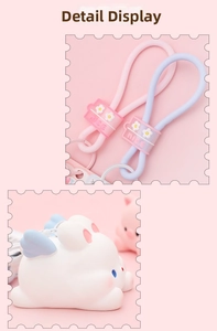 Detail of cute white bunny charm with blue wings and a purple silicone NICE lanyard