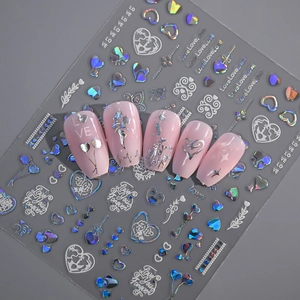 Detail of holographic silver heart and love stickers on pink false nails