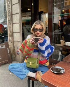 Close-up of vibrant rainbow striped chunky knit sweater with rich color-block textures