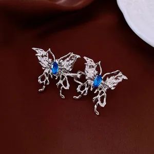 Boucles de taille papillon argentées avec cristaux bleus sur velours foncé