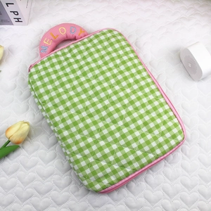 Detail of green gingham quilted laptop sleeve with pink embroidered Melody handle