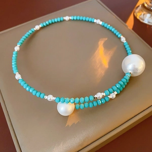 Detailed close-up of pearl and turquoise choker necklace on elegant jewelry box