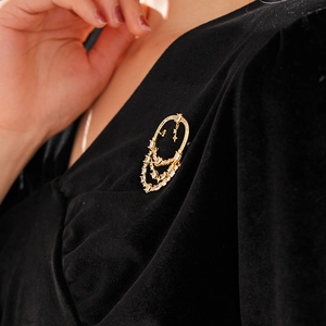 Détail de la broche ovale plaquée or 18k avec franges en zircon sur velours noir