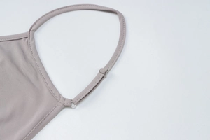 Detail of adjustable thin shoulder straps with silver metal buckles on a lilac jumpsuit